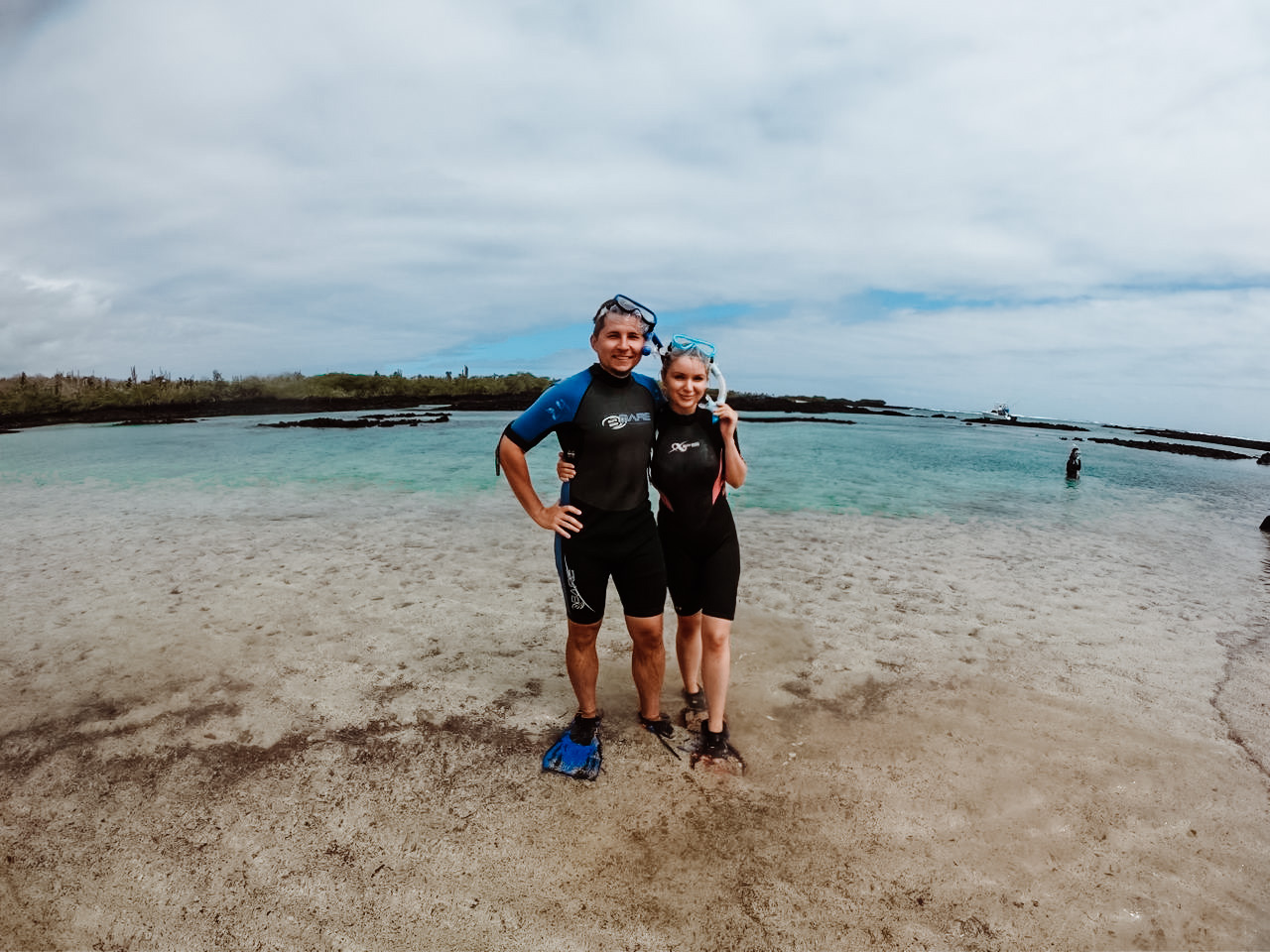 Oleg and his wife in wetsuits on a Galapagos beach during one of their cruises to Galapagos Islands