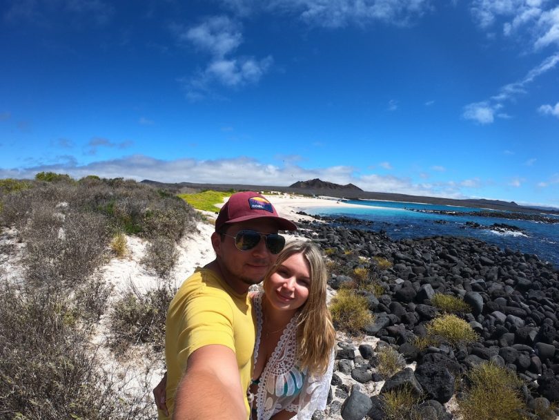 Reisepaar posiert gemeinsam an einer wilden Galápagos-Küste während unserer Hochzeits-Kreuzfahrt