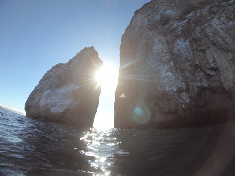 Kicker Rock rising from the Pacific Ocean during a Galapagos Islands cruise with Cruises to Galapagos Islands in beautiful weather conditions
