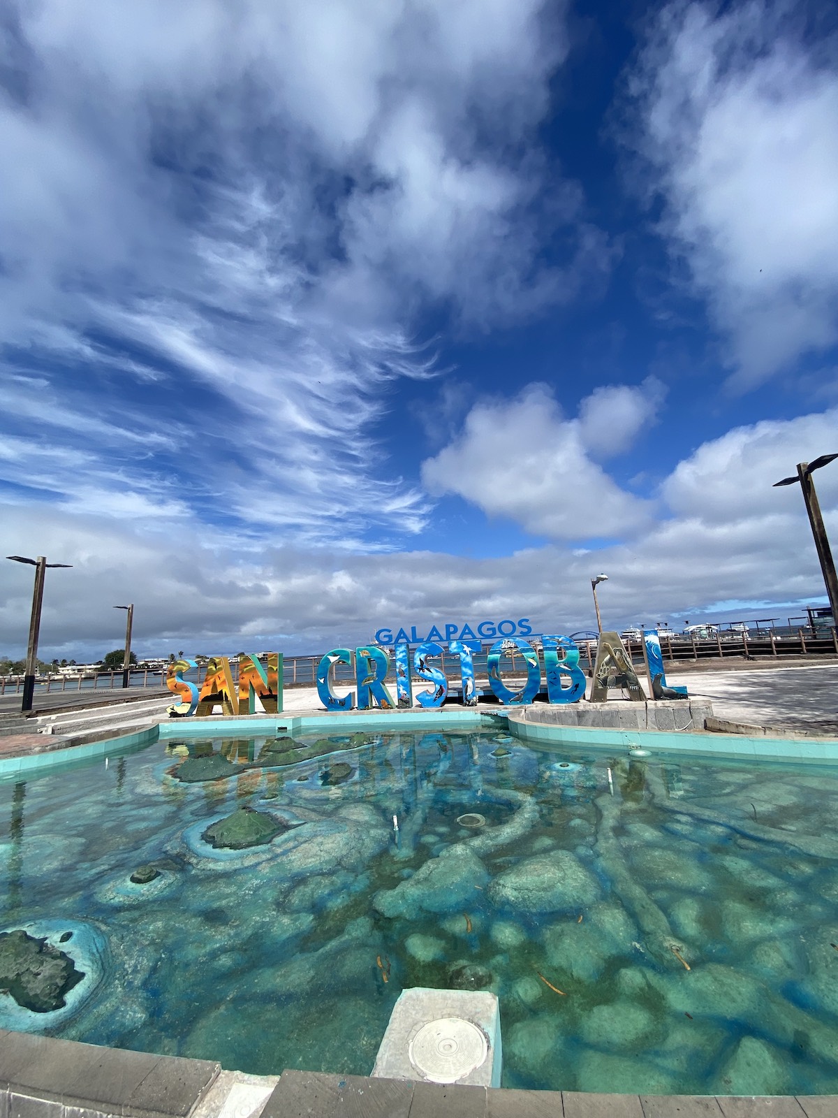 San Cristóbal Island welcome sign and waterfront view during a December Galapagos adventure with Cruises to Galapagos Islands